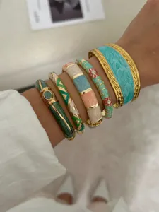 Vue détaillée de bracelets vintage en émail avec bords dorés et motifs floraux.