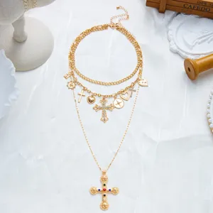 Élégant collier vintage en or à trois couches avec croix ornée, cœur et breloques soleil