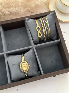 Detailansicht der goldenen Oval-Uhr und des Unendlichkeits-Armbandsets in einer Schmuckschatulle.