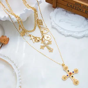 Vue détaillée d'un collier vintage doré multicouche avec pendentifs croix gemmes