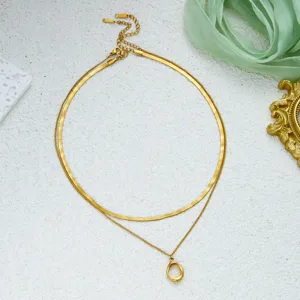 Close-up of golden minimalist snake chain necklace with oval geometric pendant