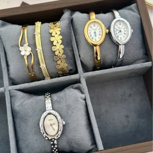 Elegante set orologio e bracciale da donna con quadranti ovali e motivi floreali oro