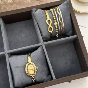 Elegantes goldenes Uhrenset mit ovalem Zifferblatt und Unendlichkeitssymbol-Armbändern