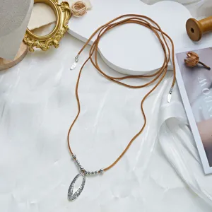 Macro detail of Bohemian vintage silver hollow pendant and brown velvet cord necklace