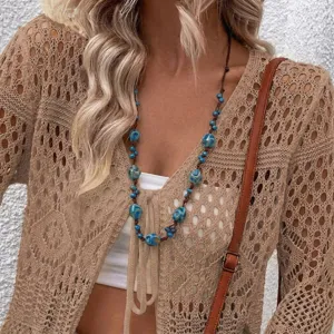 Bohemian adjustable cord necklace with blue ceramic beads worn by a female model.