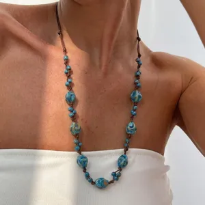 Bohemian blue ceramic bead necklace with brown knotted rope, close-up lifestyle shot