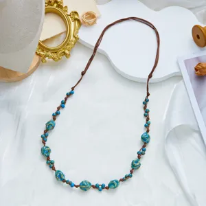 Close-up of bohemian necklace with blue ceramic beads and adjustable brown cord.