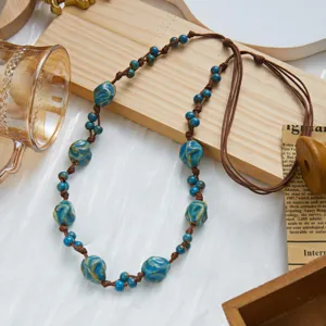 Macro view of Bohemian necklace with vibrant blue ceramic beads and adjustable brown cord
