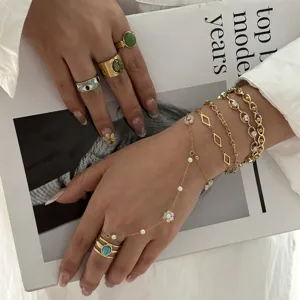 Elegante set di anelli dorati con pietre turchesi e bracciale a catena con fiori