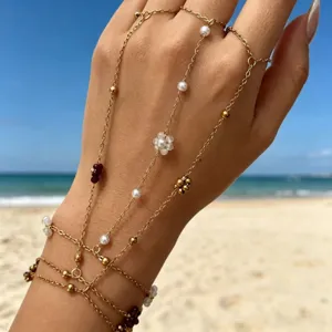 Dettaglio di un bracciale a mano multistrato in oro con perle e perline colorate