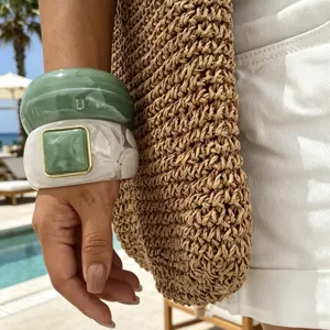 Primo piano di grossi bracciali in finta agata verde e bianca per uno stile da spiaggia.