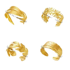 Eleganti bracciali a polsino largo aperti in acciaio inossidabile dorato con trame fogliari.