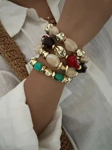 Detailaufnahme von Retro-Armbändern mit unregelmäßigen Acrylperlen und Gold-Akzenten.