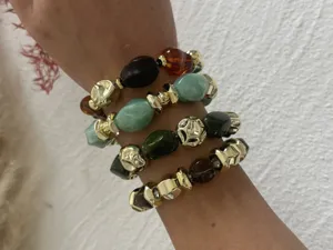 Detail von Vintage-Armbändern mit marmorierten Acrylperlen und goldfarbenen Details.