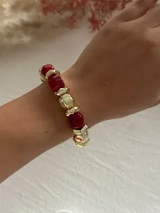 Detaillierte Makroaufnahme eines vintage Armbands mit roten Acryl- und Goldperlen