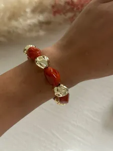 Nahaufnahme eines Vintage-Armbands mit unregelmäßigen roten Marmorperlen