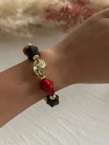 Detailansicht eines Retro-Armbands mit unregelmäßigen Acrylperlen an einem Frauenhandgelenk.