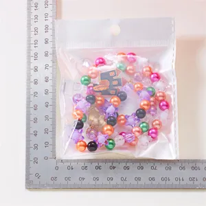 Größenreferenz für buntes Perlenarmband-Set mit festlichen Anhängern in Verpackung