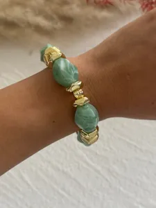 Nahaufnahme von klobigen grünen Marmor-Acrylperlen und goldenen Akzenten am Armband