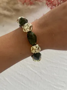 Nahaufnahme eines Armbands mit unregelmäßigen Acrylperlen und goldenen geometrischen Perlen