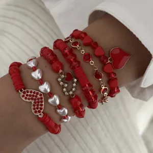 Detailed close-up view of layered Valentine red and white heart charm bracelets.