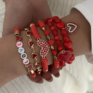 Close-up of red Valentine's Day stacked bracelet set with heart pendants and LOVE beads
