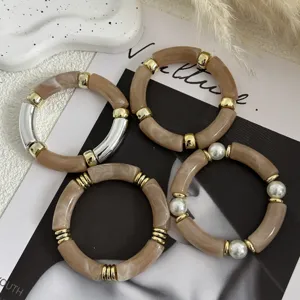 Dettaglio di quattro bracciali vintage in acrilico stile bambù in eleganti colori Maillard
