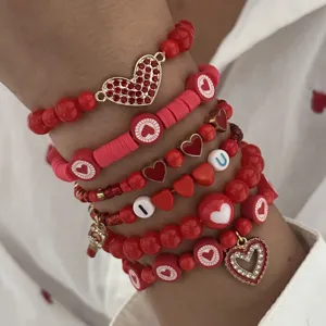Close-up of Valentine's Day stacked red bracelet set with heart charms and beads