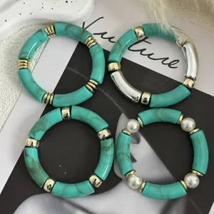 Dettaglio di bracciali in acrilico turchese con eleganti distanziatori in oro e argento