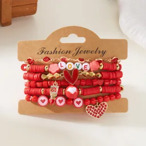 Detailopname van een rode Valentijnsdag armbandenset met hartjes en LOVE kralen.