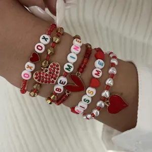 Detailed view of Valentine's Day bracelet set with red heart charms and letter beads.