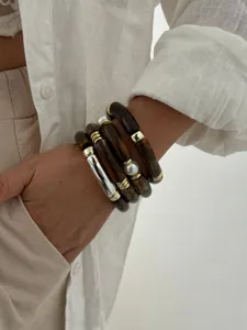 Primo piano di bracciali a tubo in acrilico retrò con perle e accenti dorati.