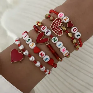 Close-up of Valentine stacked bracelet set with red hearts and letter beads