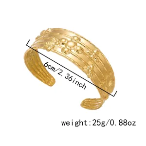 Dettaglio del bracciale rigido in acciaio dorato con rilievi di api e foglie eleganti