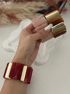 Makroansicht einzigartiger gestreifter Acetat-Acryl-Resin-Armbänder mit Goldakzenten.