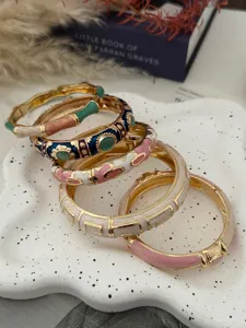 Close-up of colorful enamel bamboo-joint bangles with intricate dripping glaze patterns.
