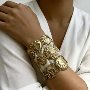 Vista dettagliata di un bracciale a fascia dorato con motivi di fiori e conchiglie