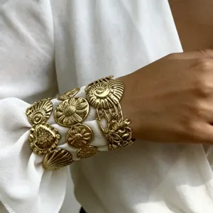Primo piano di un bracciale rigido in acciaio inossidabile dorato con motivi floreali vintage
