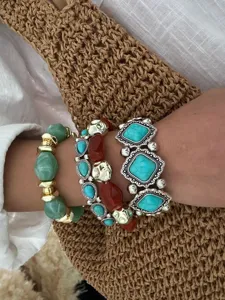 Detailweergave van Boheemse turquoise meerlaagse armbanden met retro cowboy-stijl