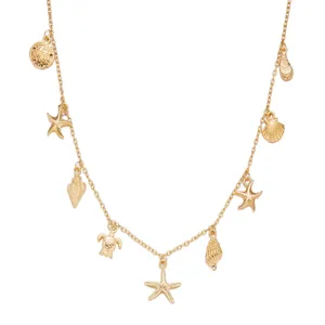 Detailed macro view of gold ocean charms necklace featuring starfish and sea turtle pendants