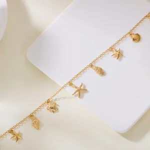 Close-up of gold necklace featuring starfish, seashell and turtle beach charms