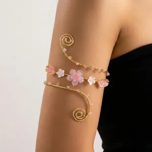Vista dettagliata di un bracciale da braccio a spirale dorato con fiori di rosa e perline