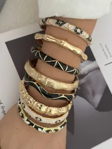 Detailansicht von Vintage-Armreifen mit Bambustextur und Augenmustern am Arm getragen.
