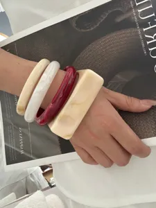 Set aus geometrischen Retro-Armbändern aus dickem Acryl in Elfenbein und Rot