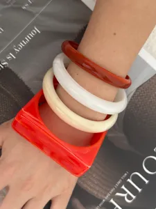 Nahaufnahme von geometrischen Acryl-Armreifen in quadratischen und runden Formen