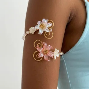 Dettaglio di un elegante bracciale da braccio floreale con petali rosa e cangianti