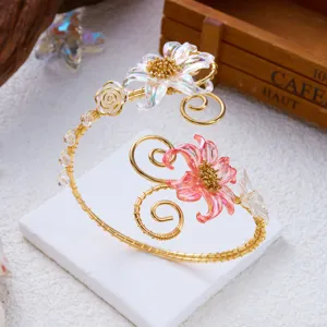 Dettaglio macro del bracciale da braccio in filo d'oro con accenti floreali
