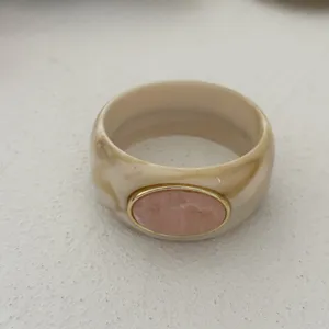 Detailed view of vintage marbled resin wide bangle with pink faux stone oval inlay