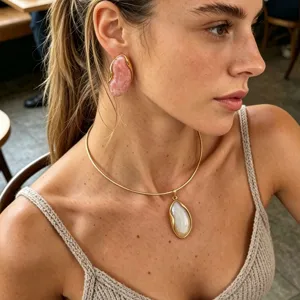 Close-up detail of model wearing vintage gold resin earrings and thin collar necklace