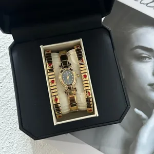 Gold oval watch and red heart bracelet set in a luxury black jewelry gift box presentation.